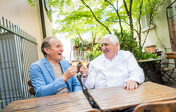Anstossen auf eine erfolgreiche Zusammenarbeit: Michel Péclard (l.) und Jacky Donatz im Garten des Restaurants Coco. (Thomas Lüthi)